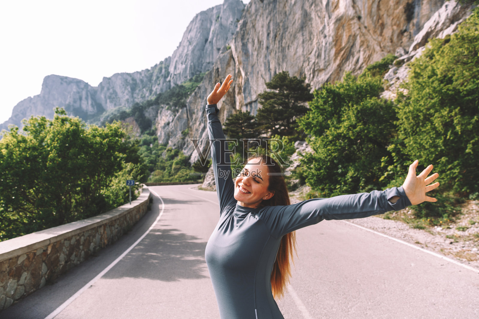 自由旅行者妇女站在举起的手臂,享受美丽的自然照片摄影图片