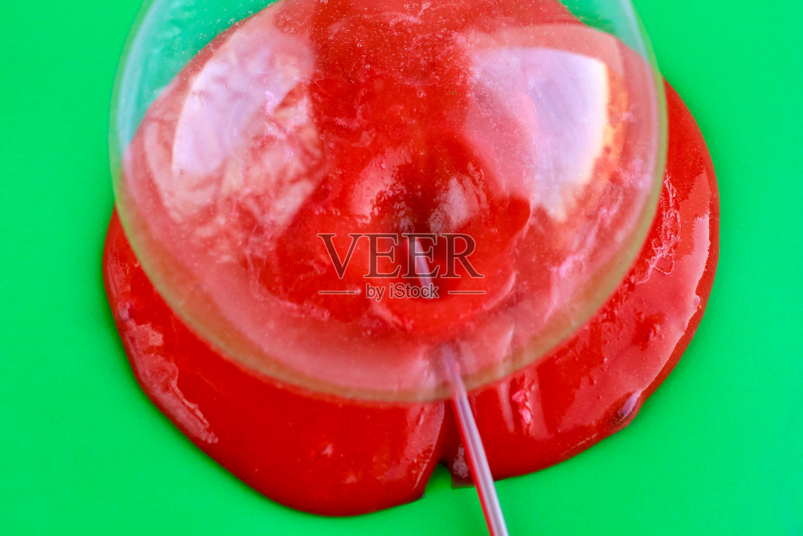 绿色背景上的鲜红色黏液。教育、创造力、童年观念。有选择性的重点。照片摄影图片