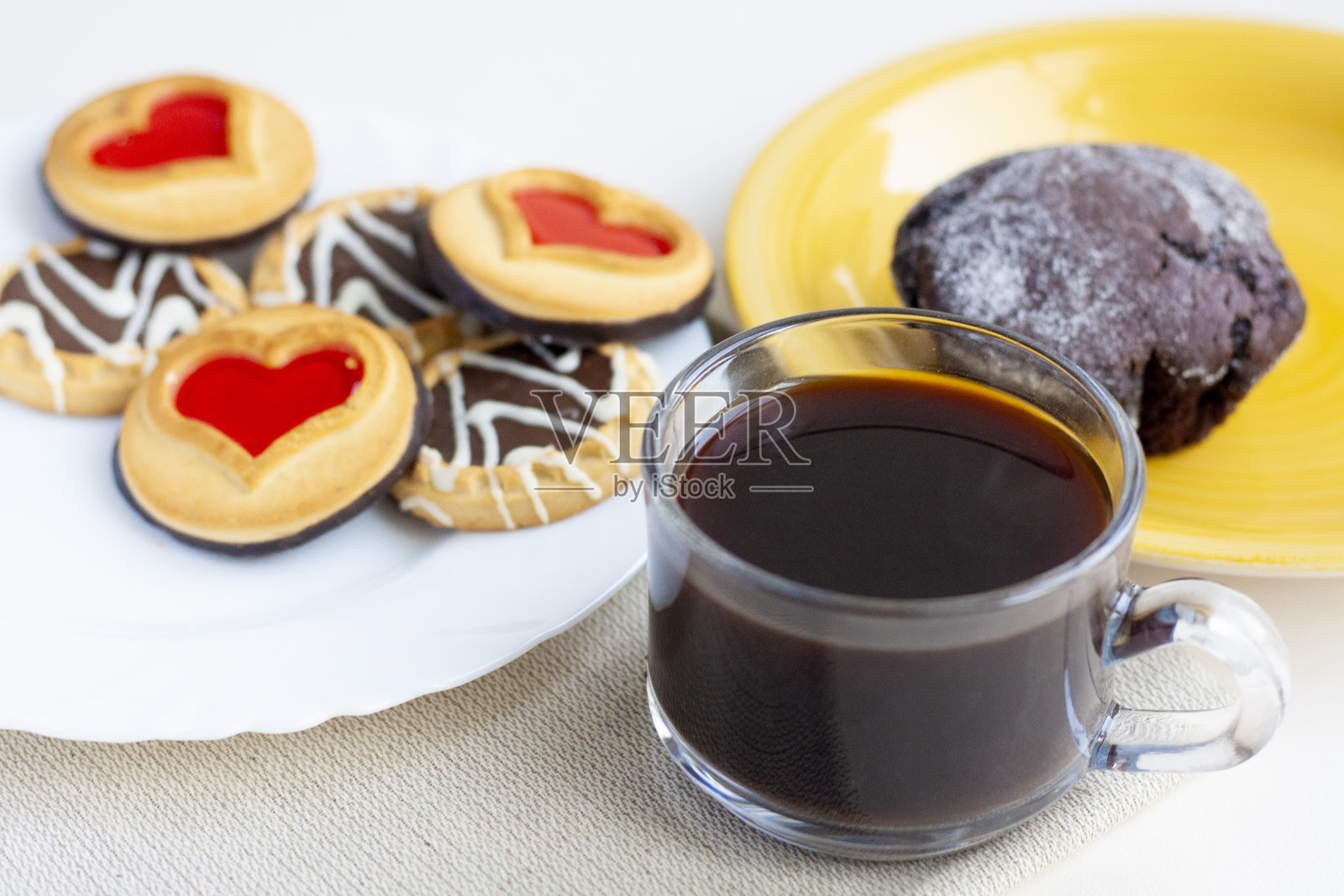 早餐,杯子里的咖啡,黄色盘子里的巧克力松饼,白色盘子里的饼干照片摄影图片
