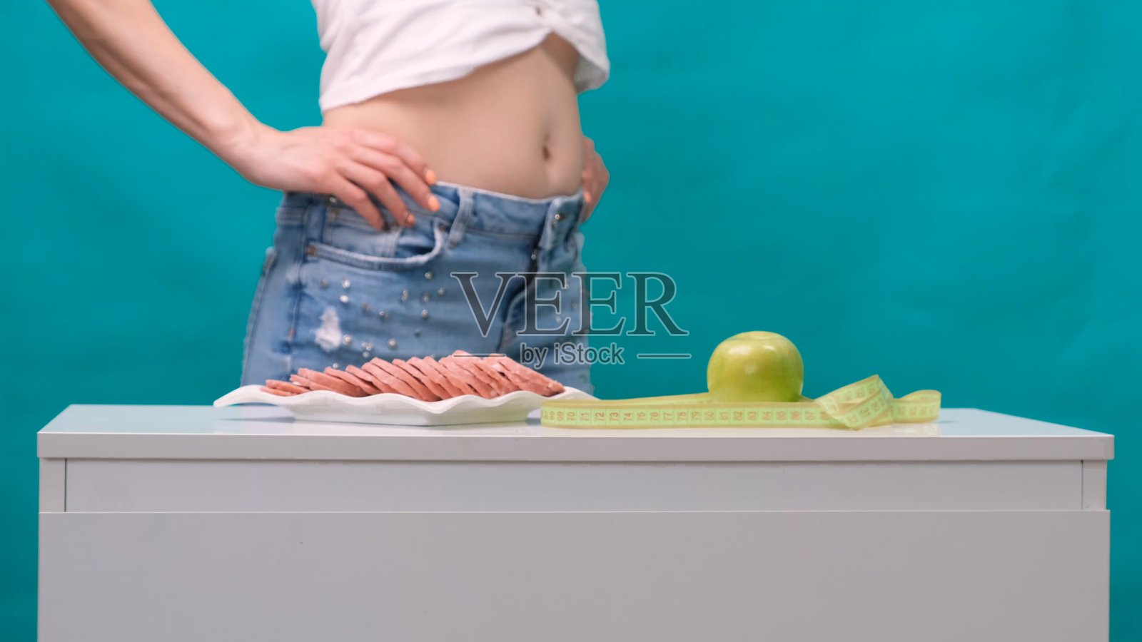 健康的生活方式、饮食和运动理念。女人的手在青苹果和香肠之间挑照片摄影图片