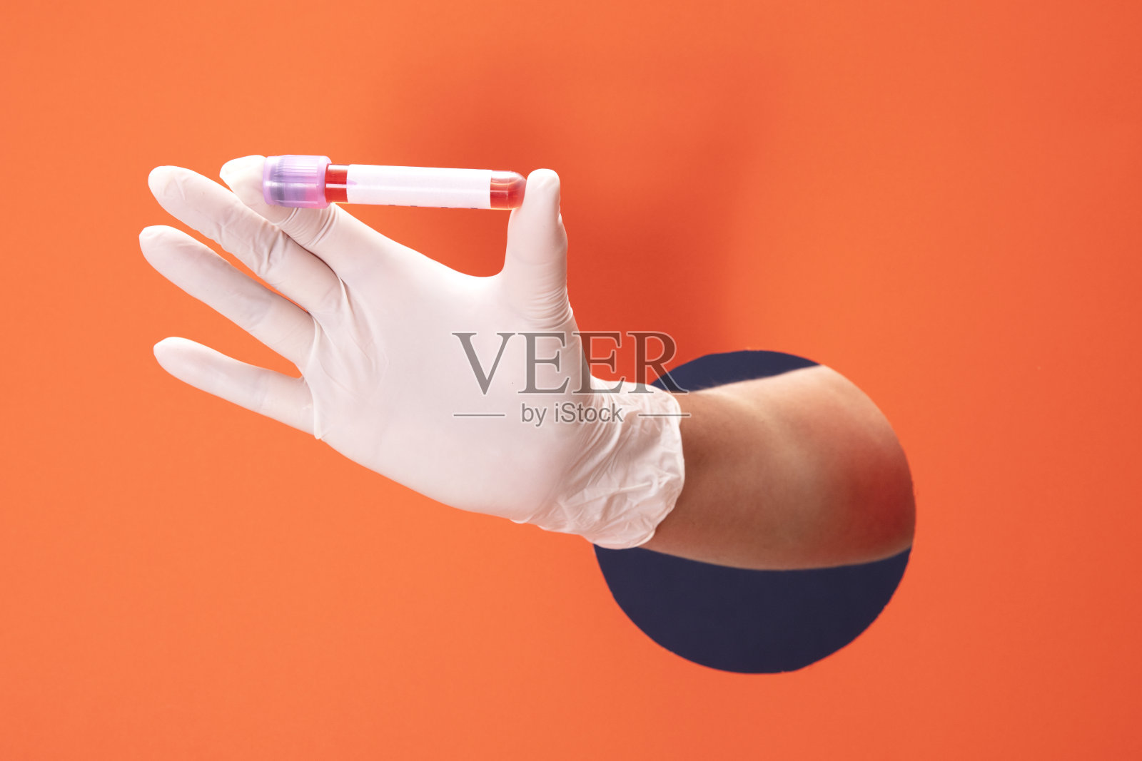 医生手持白色医用手套,手持并展示Covid-19血液样本管照片摄影图片