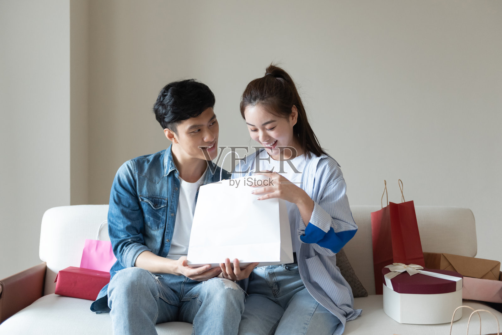 一对年轻的亚洲夫妇在沙发上介绍彼此照片摄影图片