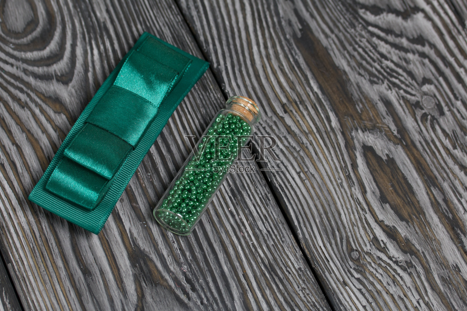 绿色的珠子用于刺绣和发夹。在涂成黑白的松木板上。照片摄影图片