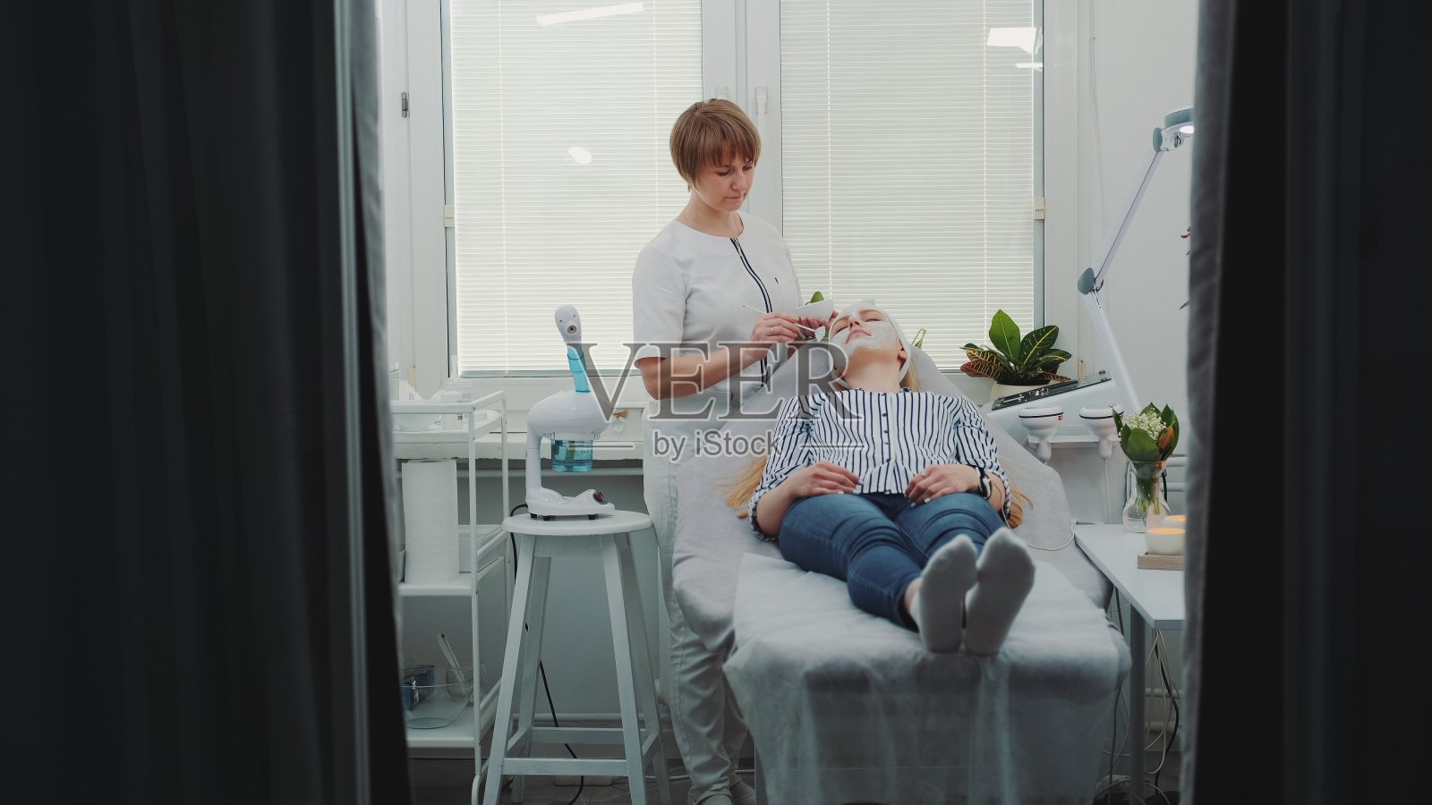 美容师在美容院给美女敷面膜照片摄影图片