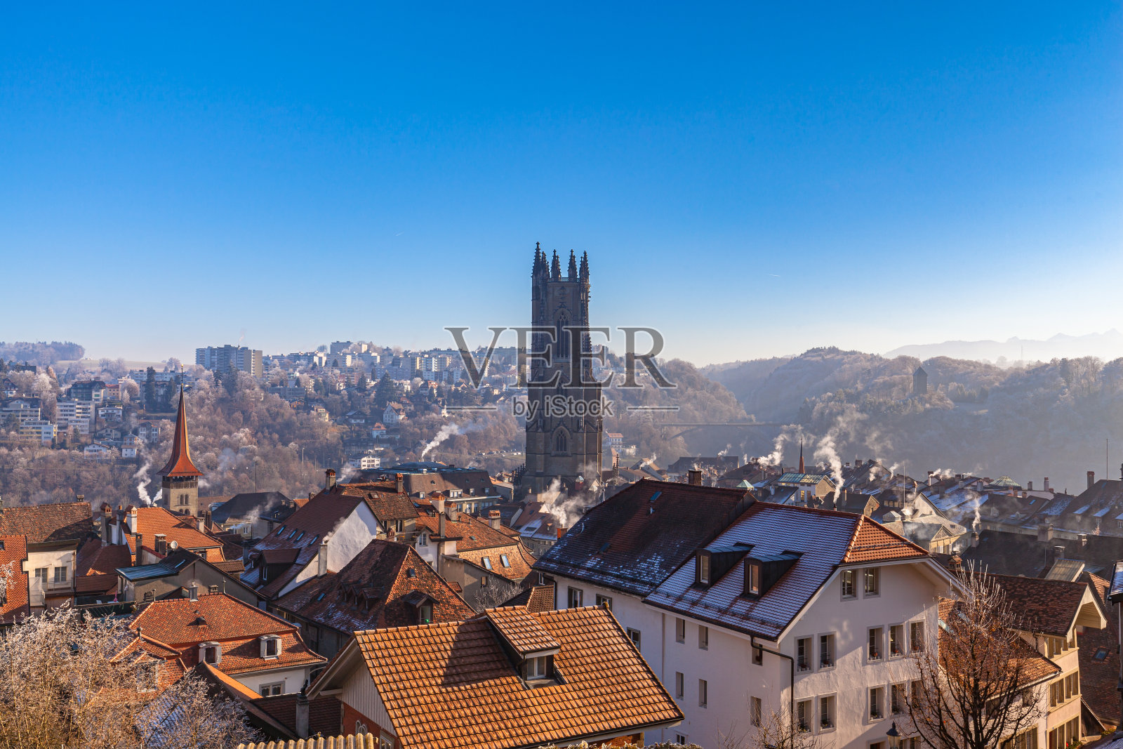 航拍的弗里堡城市景观在一个阳光明媚的冬日里弗里堡大教堂和霜冻覆盖的建筑和蓝天的背景,瑞士照片摄影图片