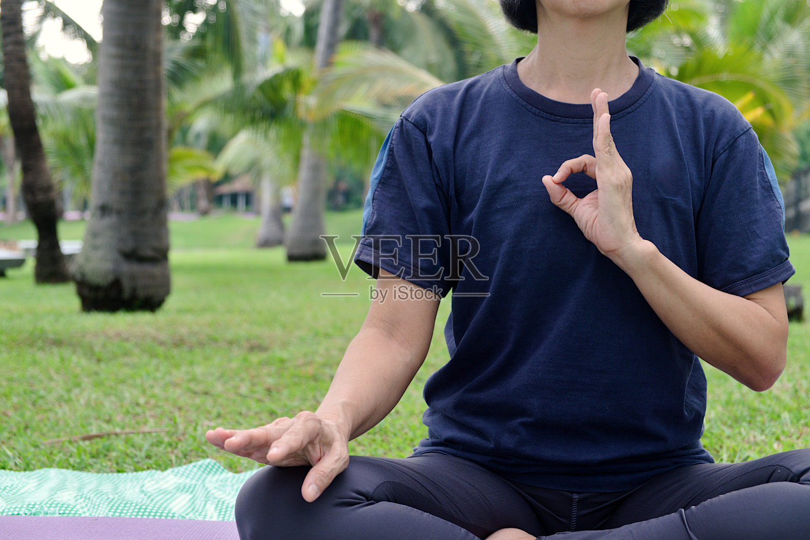 身体的一半亚洲女人谁玩瑜伽练习在公共公园早上照片摄影图片