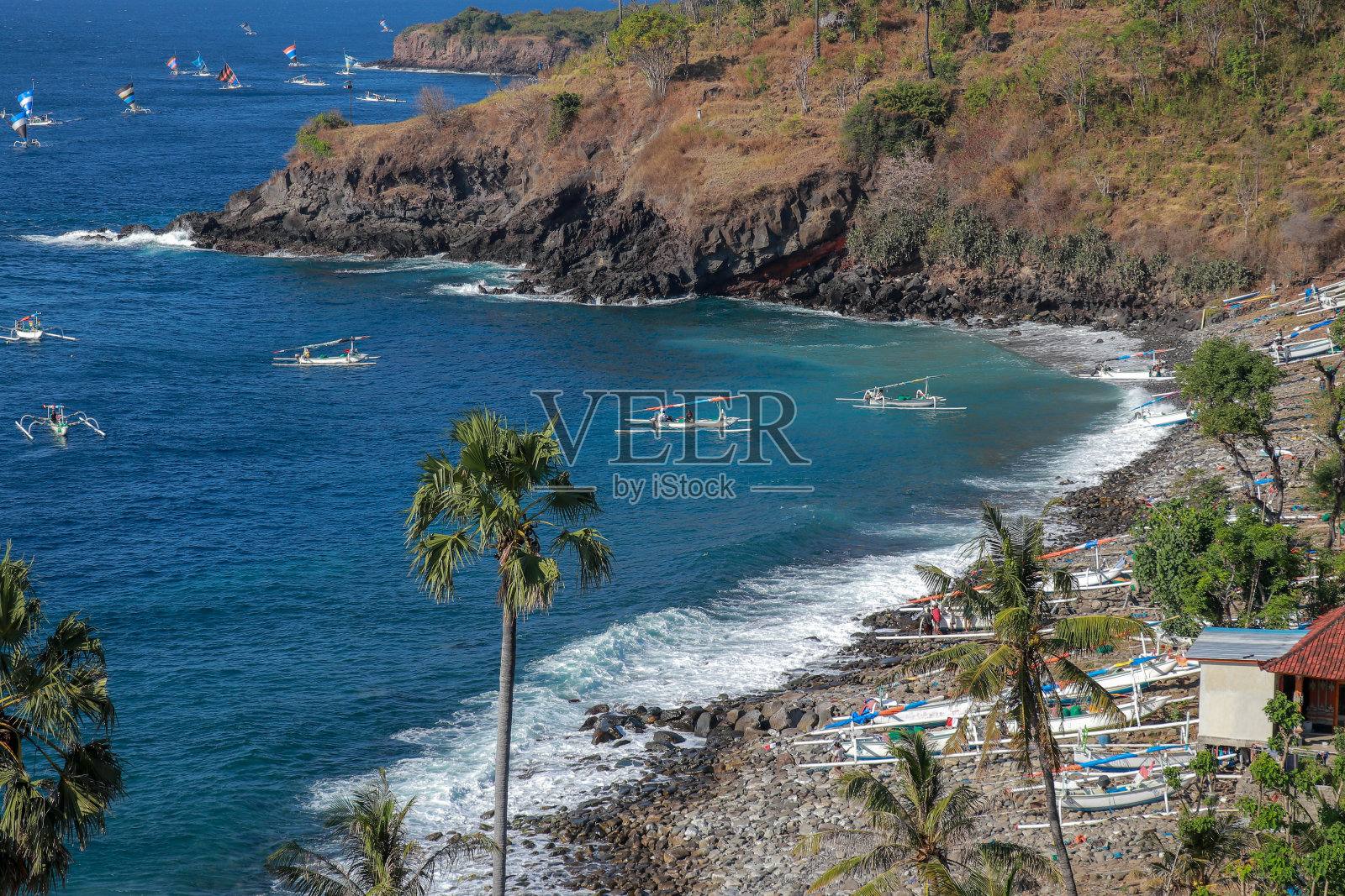 2019年7月29日,印尼巴厘岛,一名渔民乘坐传统的jukung独木舟,带着捕获的鱼返回日本巴厘岛阿米德海滩照片摄影图片