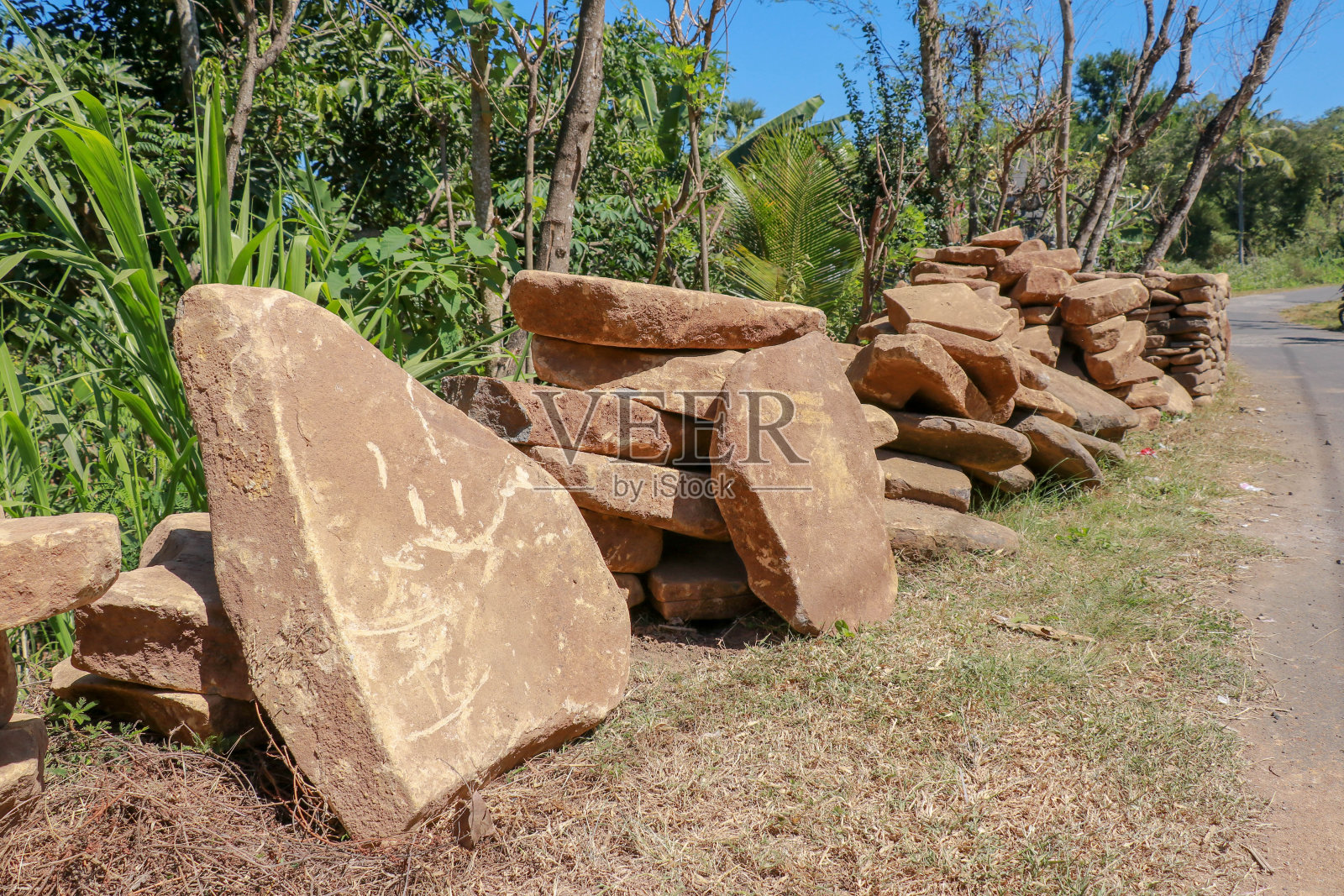 大而平的黄色石头作为通道。天然建筑材料。一堆一堆准备出售的巨石。巨大沉重的石头照片摄影图片