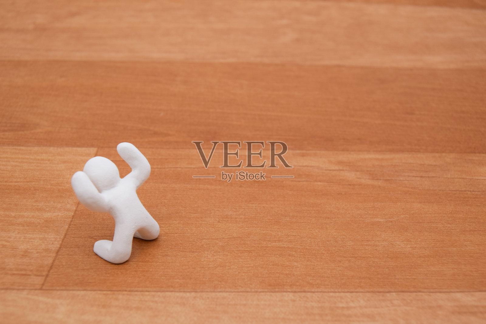 概念形象的一个快乐的泥娃娃在一个木制的背景。白色的颜色和简单的风格娃娃。照片摄影图片