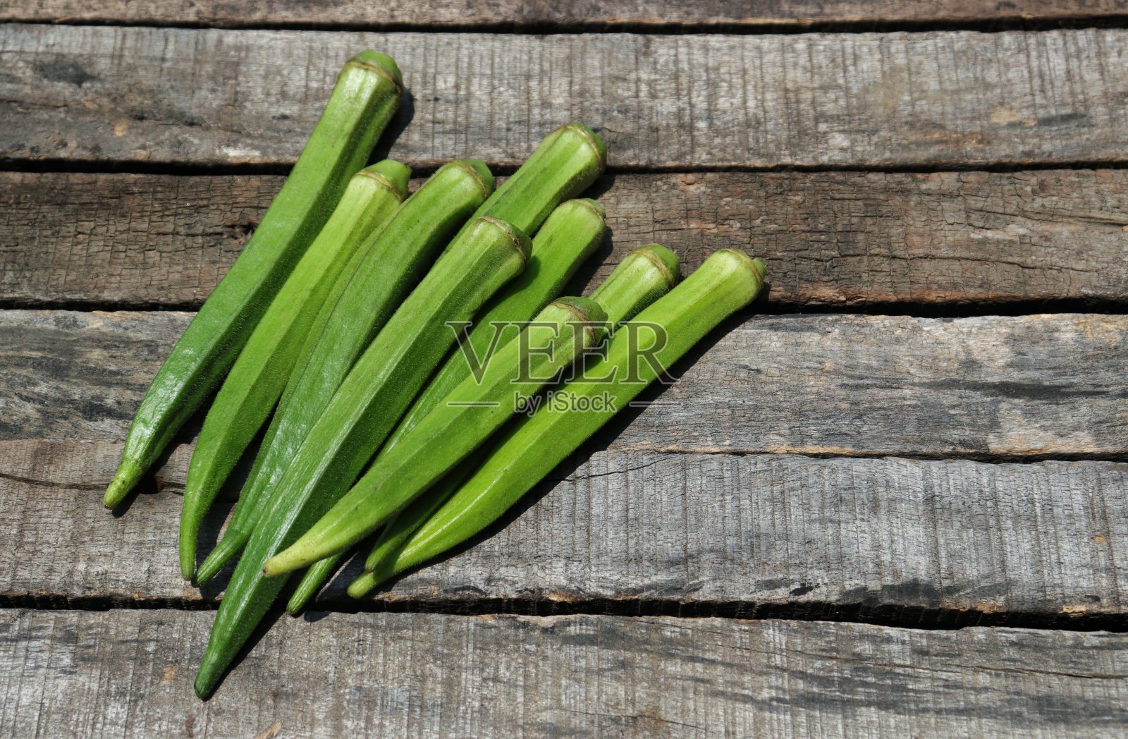 生女士手指或秋葵蔬菜孤立的木制背景与复制空间照片摄影图片