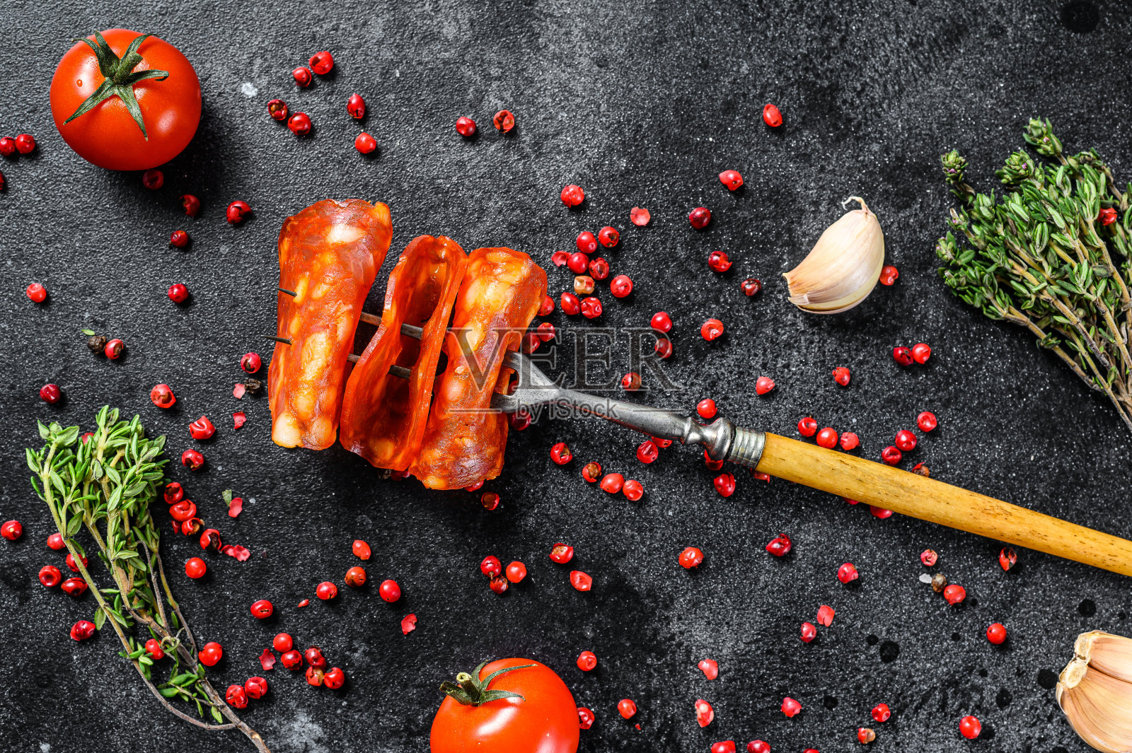 切得很薄的西班牙香肠。西班牙腊肠加香料,红辣椒,胡椒。辣的食物。黑色背景。俯视图照片摄影图片