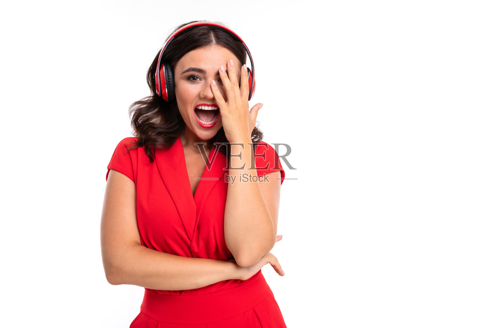 一个红嘴唇的年轻女子戴着耳机听着音乐,尖叫着照片摄影图片