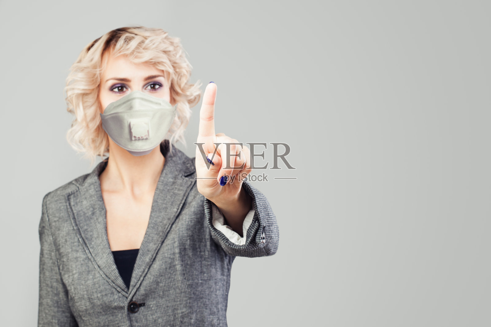 手指。戴着面罩的女人推着白色背景照片摄影图片