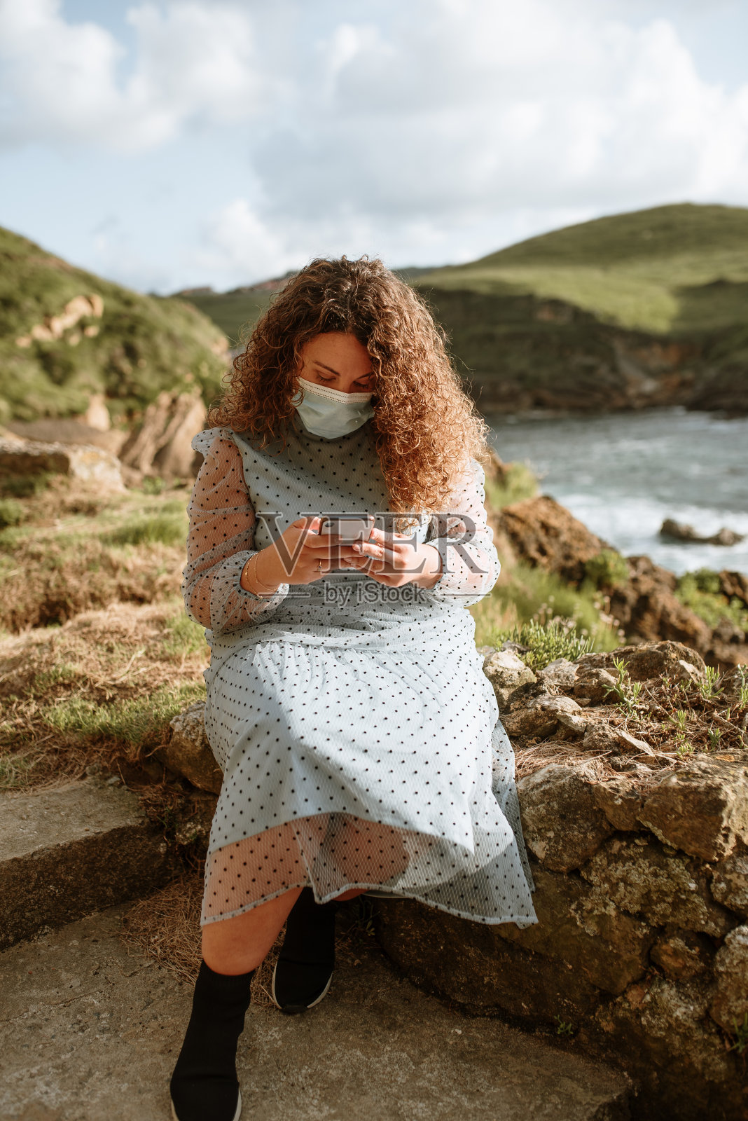 年轻女子使用智能手机和保护面罩照片摄影图片