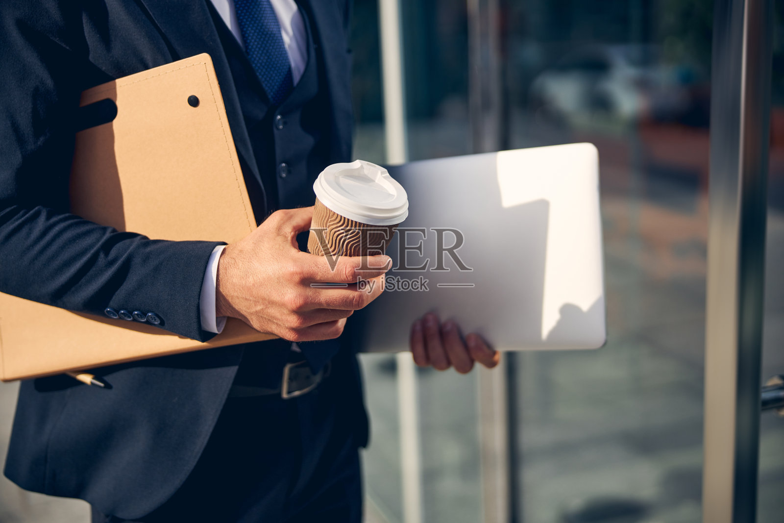 手里拿着文件和饮料的男人照片摄影图片