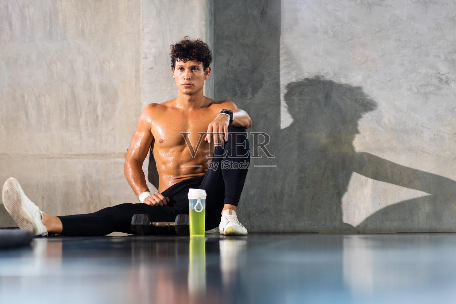 运动员训练结束后,在体育馆用格斗绳休息,在运动俱乐部坐着喝水。健康的生活方式和健身理念。照片摄影图片