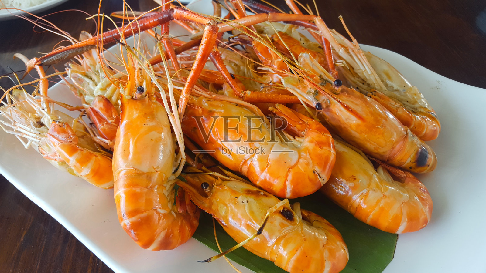 烤虾。烤巨河虾在盘中。照片摄影图片