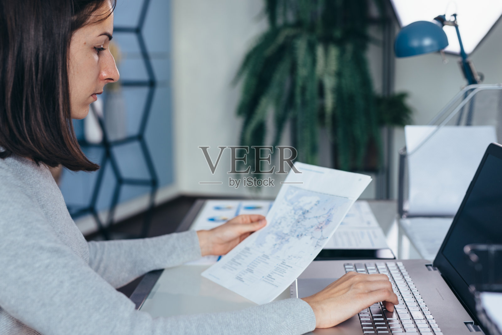 女商人坐在办公桌前研究商业文件照片摄影图片