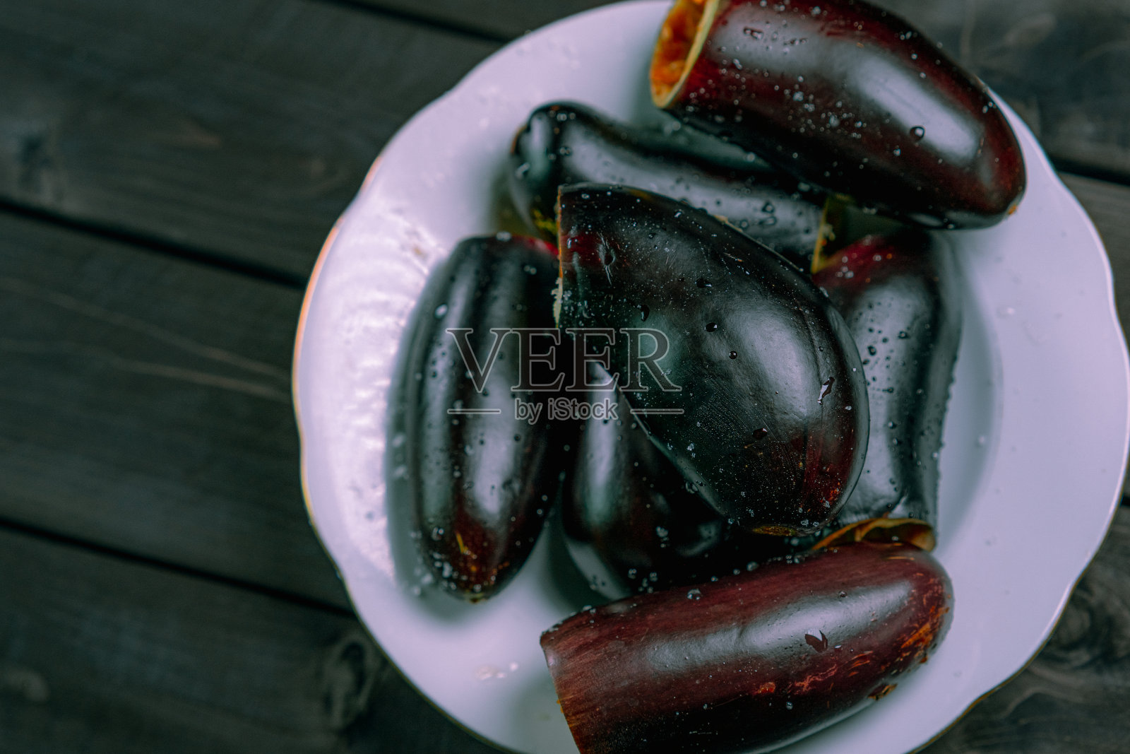 将茄子去皮,放在木盘上照片摄影图片