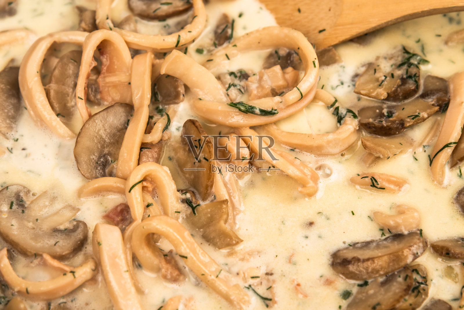 用鱿鱼和蘑菇制作奶油酱。特写镜头照片摄影图片