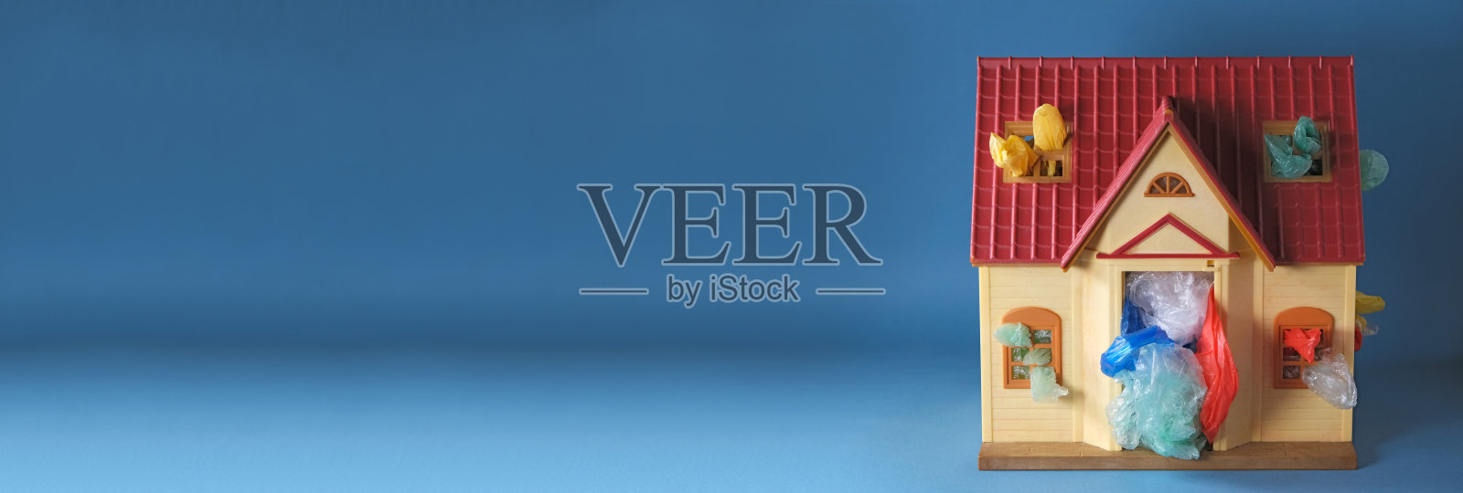 玩具屋内使用的彩色塑料袋,蓝色背景,私人家居垃圾堆积问题,环境污染或家庭污染问题,横幅复制空间照片摄影图片