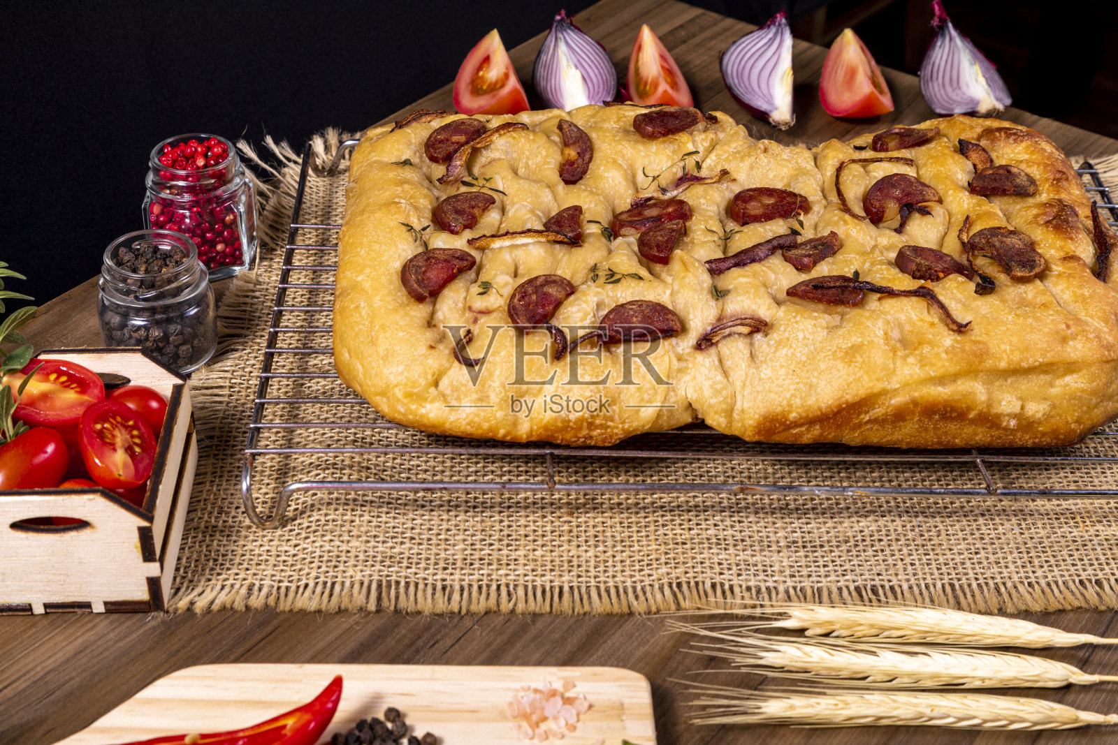 传统的意大利佛卡夏配上意大利辣香肠、樱桃番茄、黑橄榄、迷迭香和洋葱——自制的佛卡夏扁平面包照片摄影图片