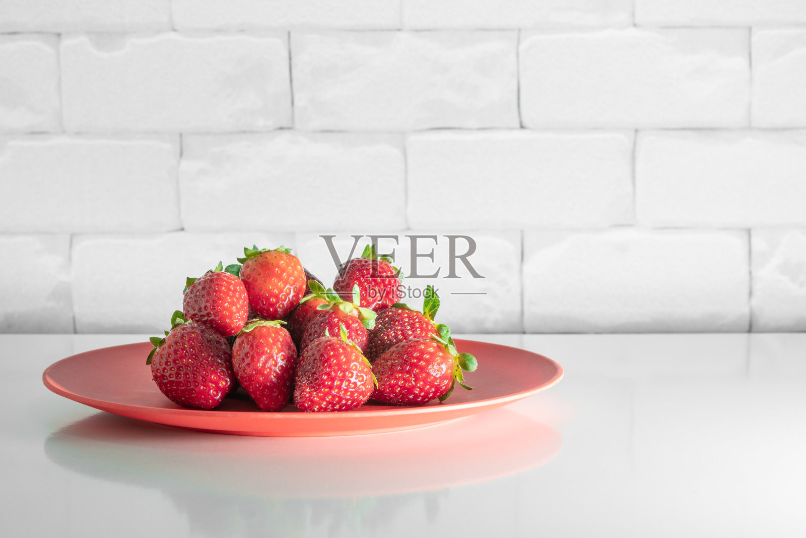 白色的桌子上放着巴西草莓。照片摄影图片