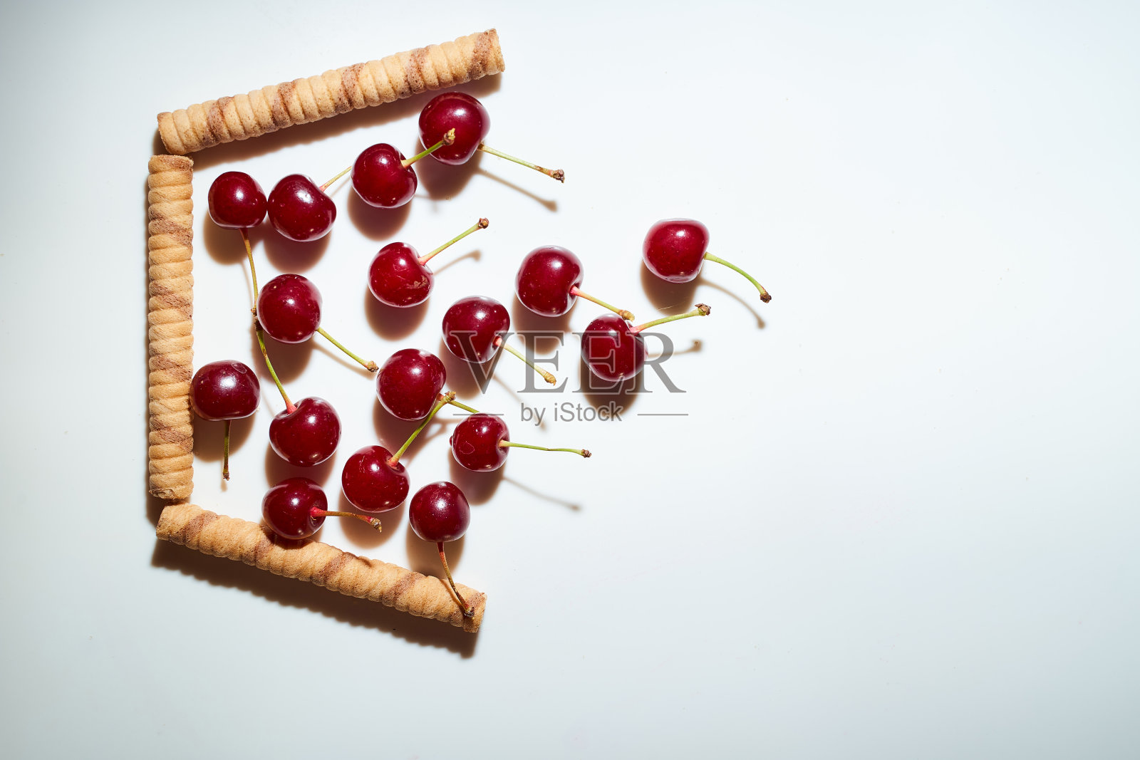 一组樱桃,白色背景和阴影。落在从巧克力棒概念照片的临时篮子。广告照片。俯视图照片摄影图片