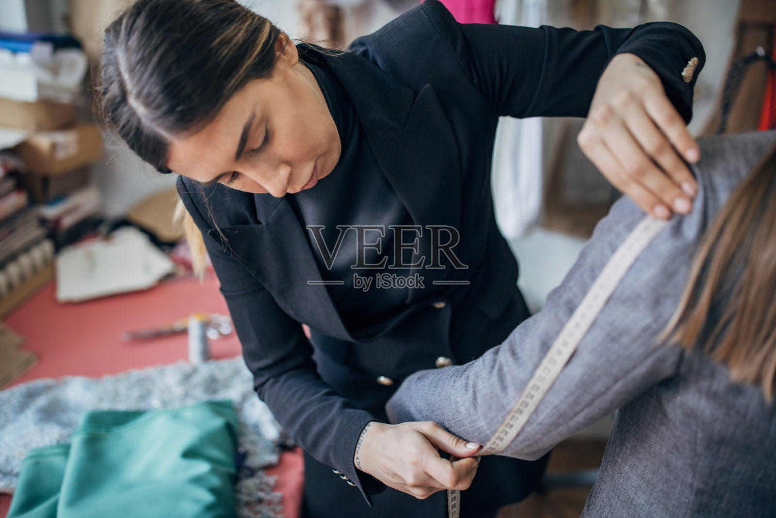 一位时装设计师为女士量尺寸照片摄影图片