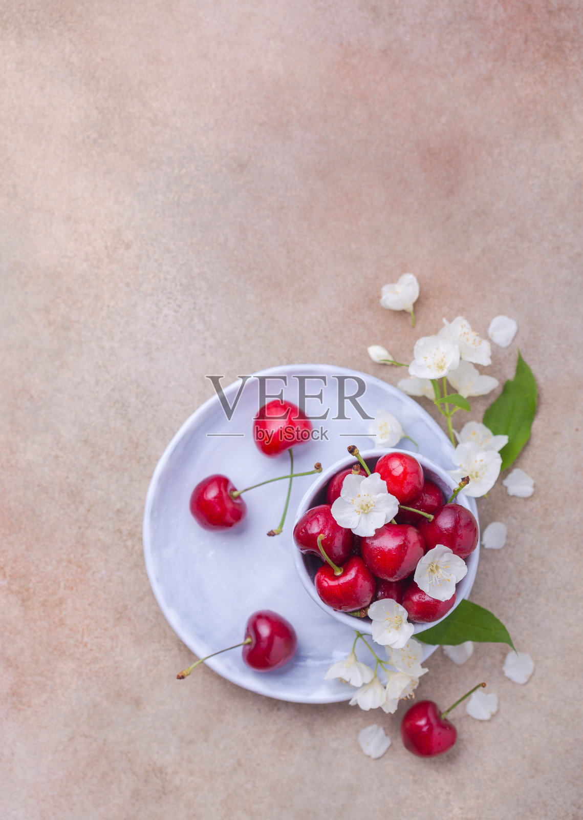 新鲜的甜樱桃和漂亮的白色花瓣放在碗里照片摄影图片