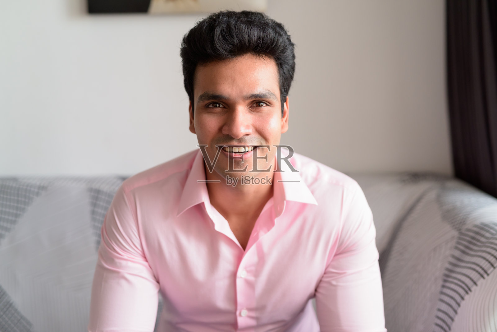 年轻的印度商人微笑着待在家里照片摄影图片