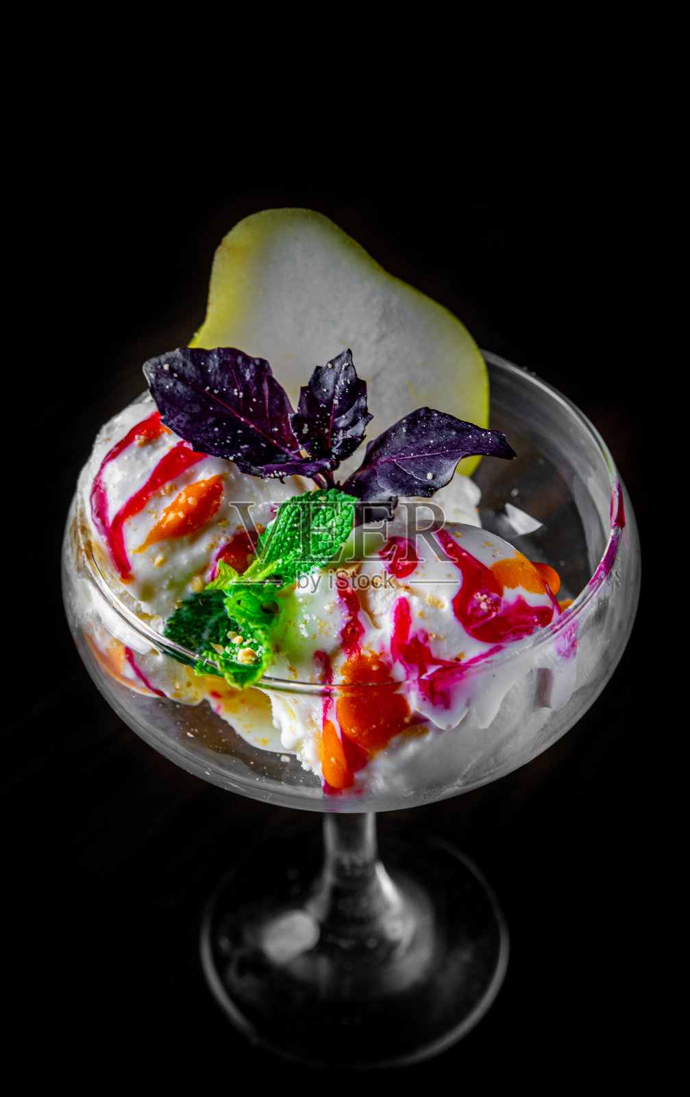 美味的冰淇淋装饰玻璃水果在黑色的背景照片摄影图片