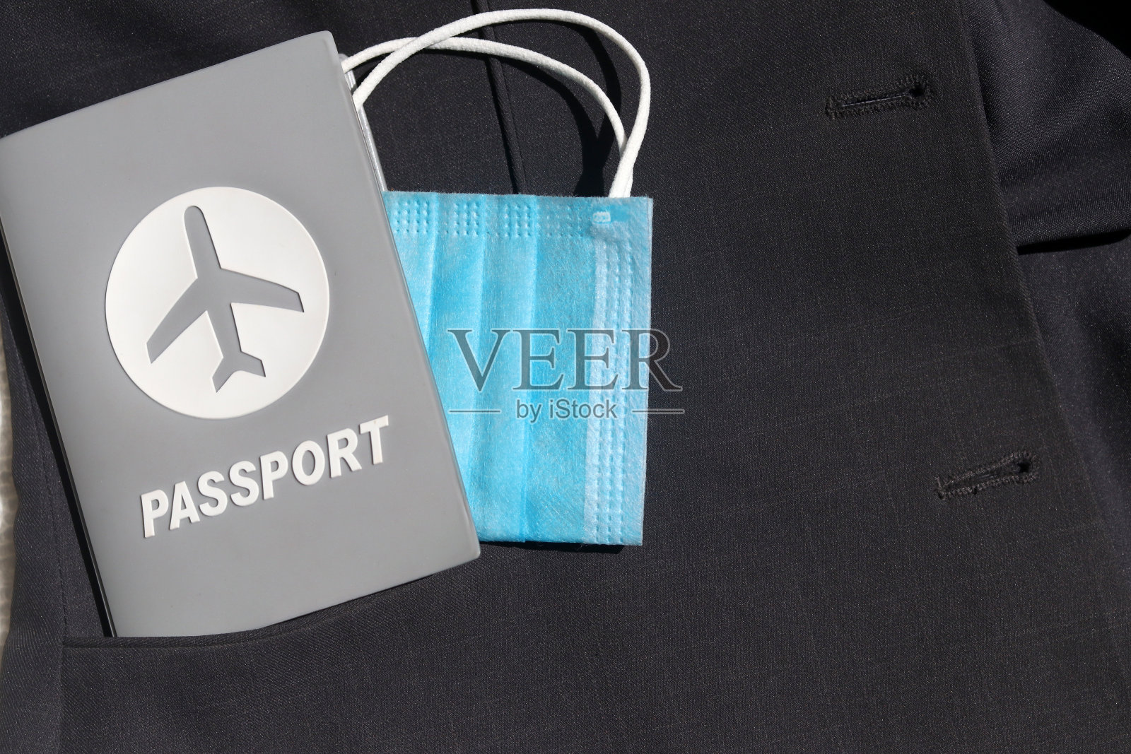 带医用口罩的护照,西装外套口袋背景,有拷贝空间。照片摄影图片