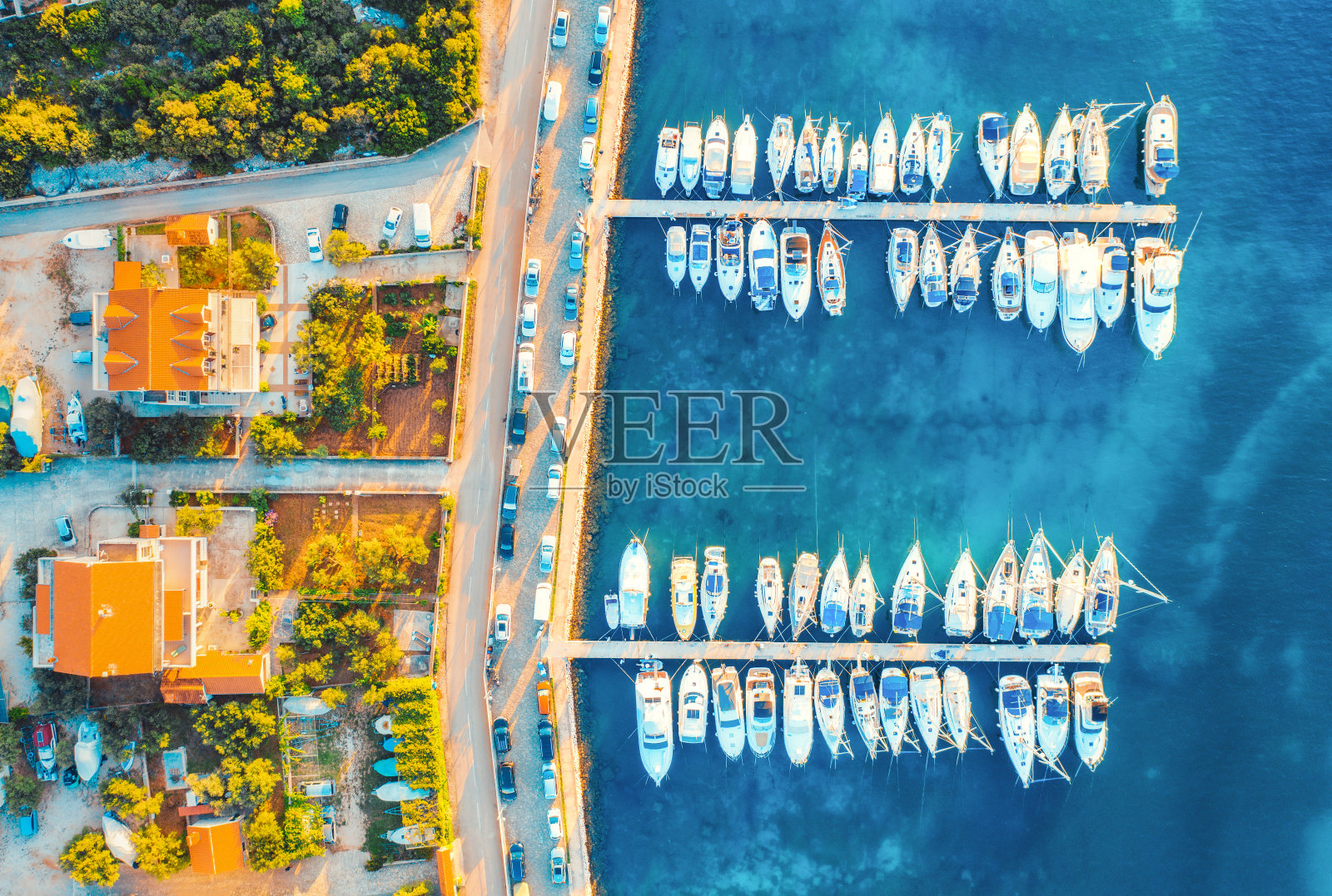 鸟瞰图的船只和游艇港口在美丽的老城在夏天日落在克罗地亚。景观与建筑物与橙色屋顶,摩托艇在港口,清澈的蓝色海洋,汽车,道路。俯视图照片摄影图片