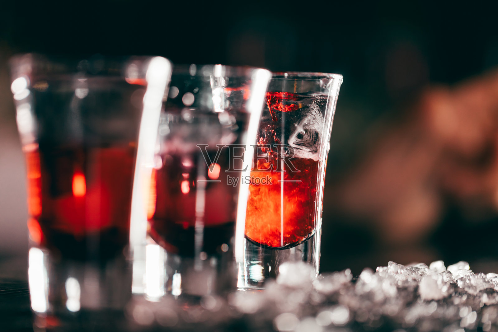 红色鸡尾酒在玻璃隔离在模糊的餐厅背景。照片摄影图片