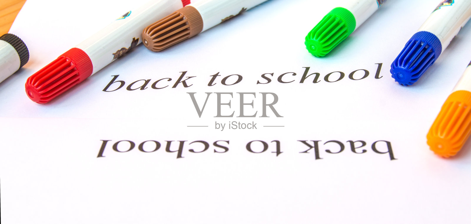 一张白纸上写着返校的题词,用彩色的记号笔画画,教育的理念照片摄影图片