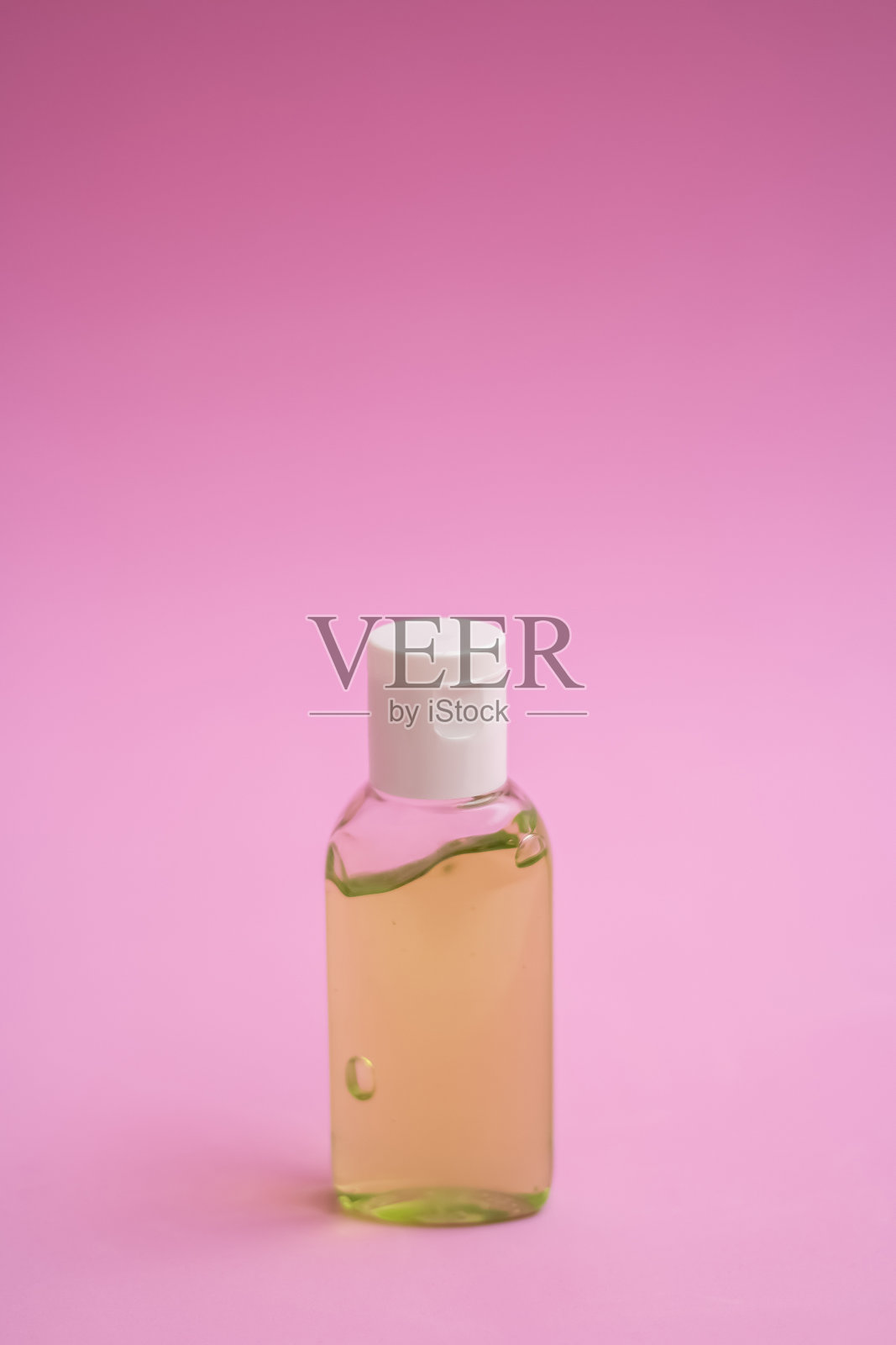 粉红色背景上的消毒瓶照片摄影图片