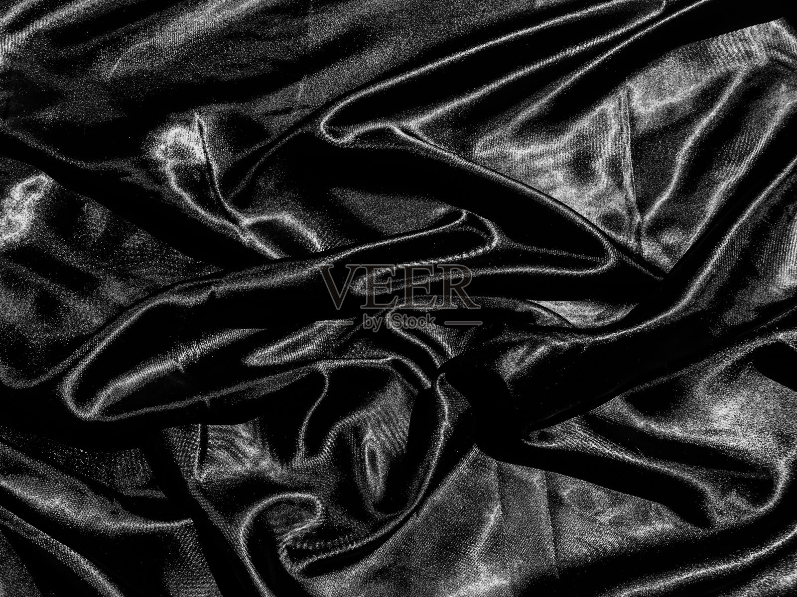 黑色布料或织物纹理背景,带有液体波状或波浪状褶皱。壁纸的设计照片摄影图片
