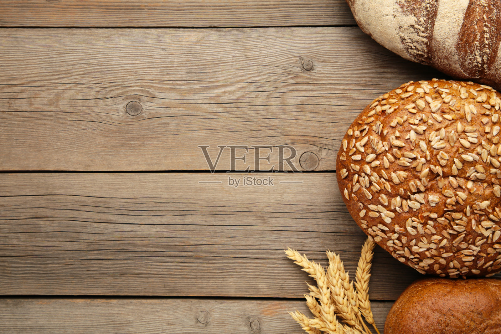 带小麦小穗的新鲜黑面包放在有复印空间的灰色木桌上照片摄影图片