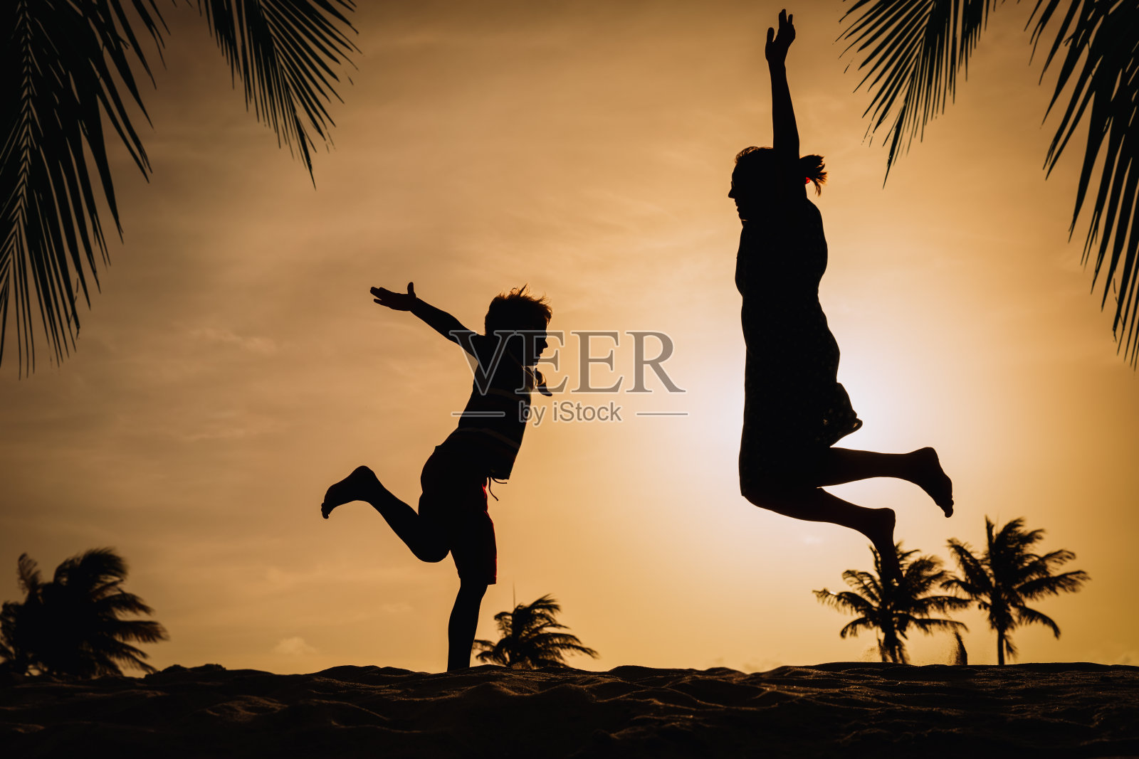 母亲和儿子玩日落,一家人享受热带度假照片摄影图片