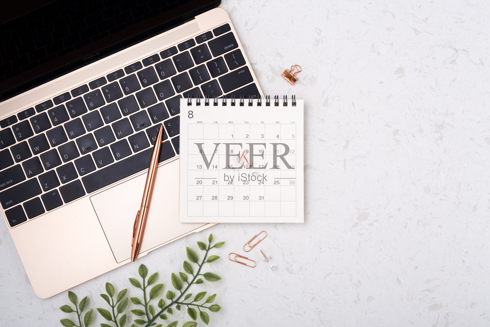 笔记本电脑上带有玫瑰金笔的日历照片摄影图片