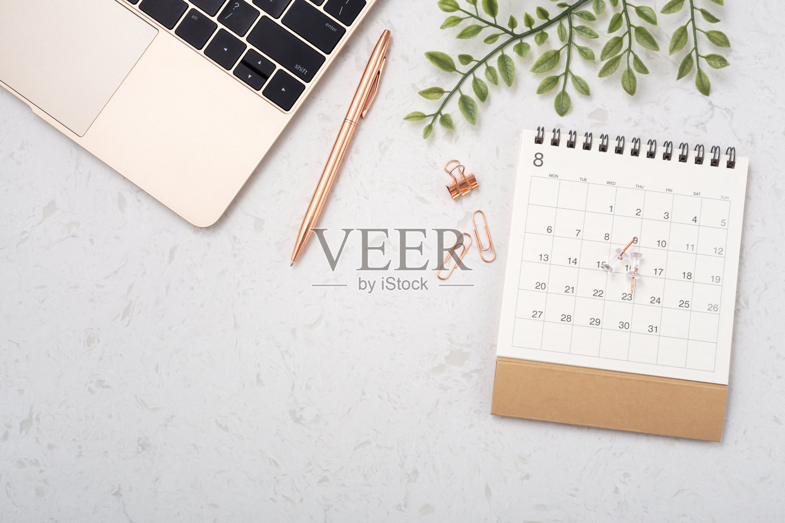 日历和笔记本电脑放在白色石英桌上照片摄影图片