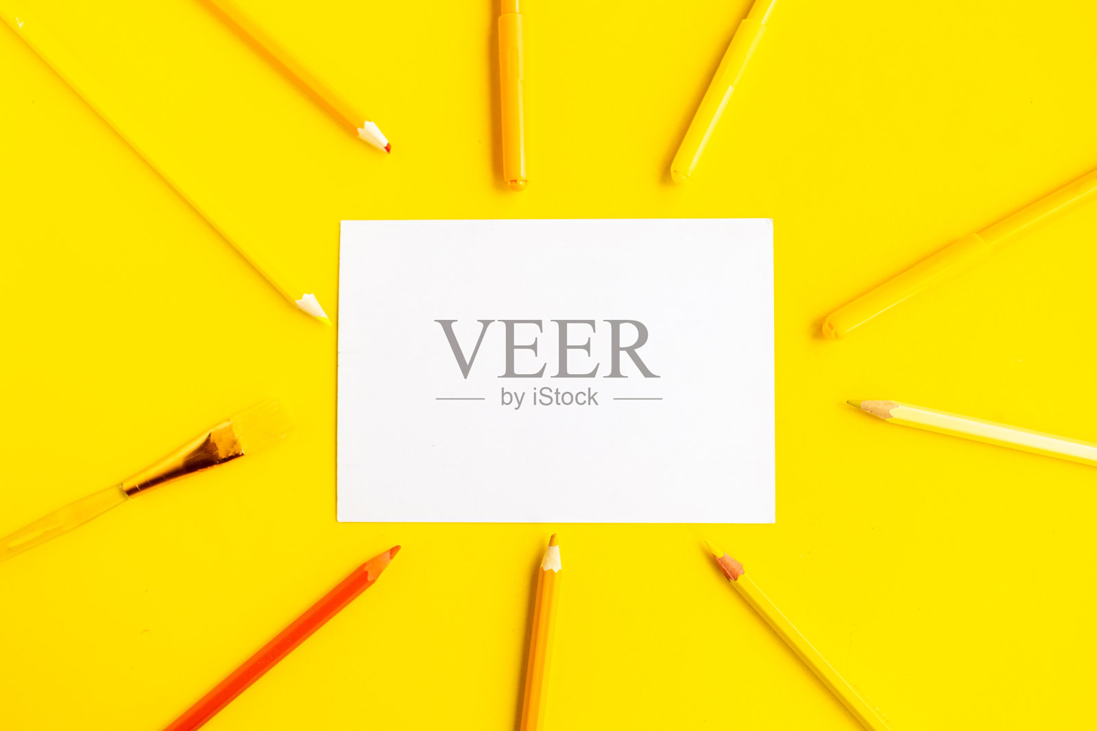 彩色铅笔和白色模型空白黄色背景,俯视图照片摄影图片