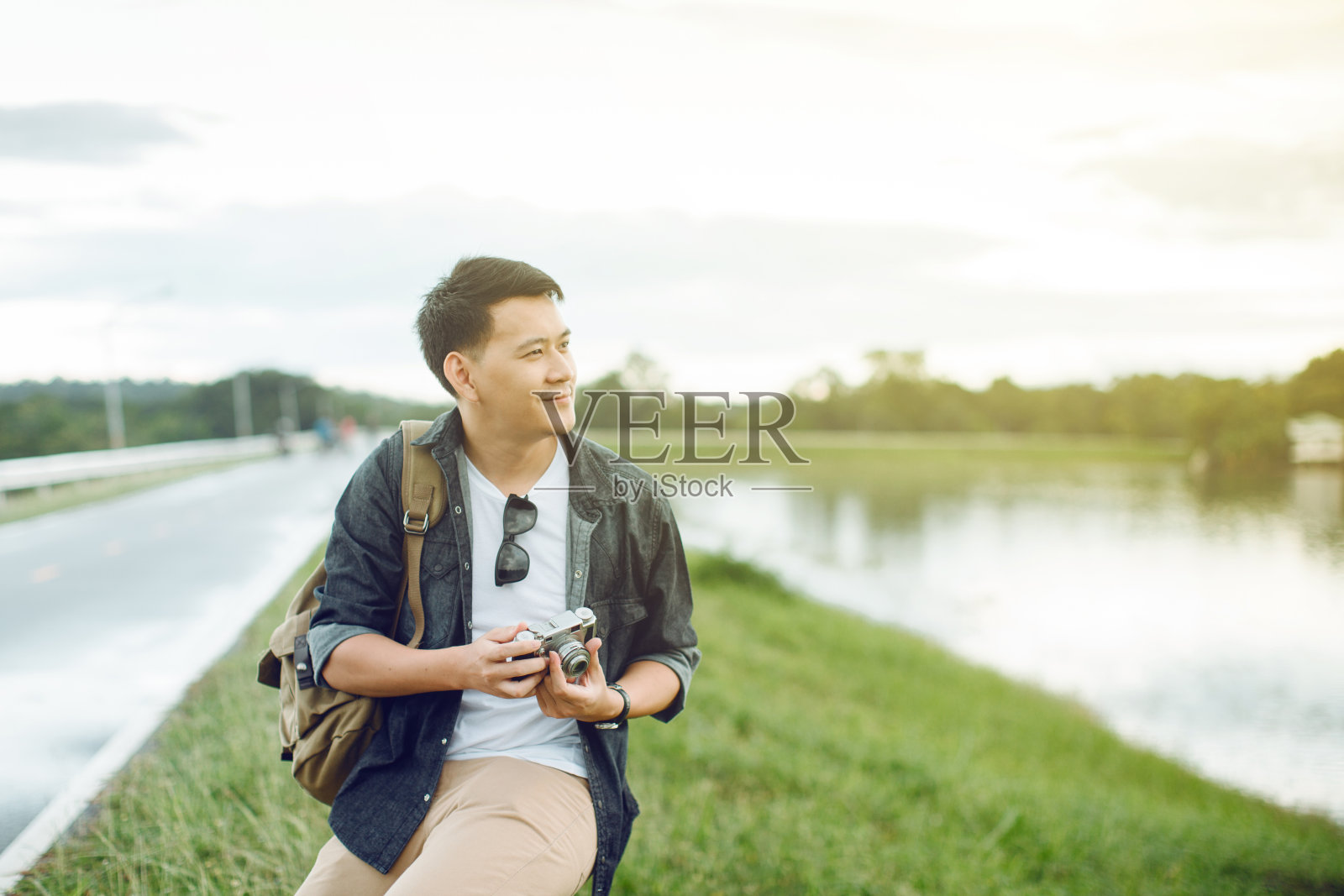 快乐的年轻亚洲男人背着背包在户外。旅行的概念。照片摄影图片