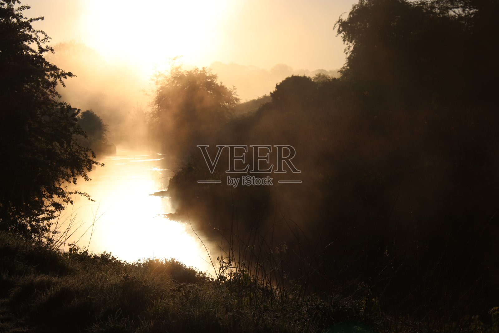 黎明越过一条雾蒙蒙的河照片摄影图片