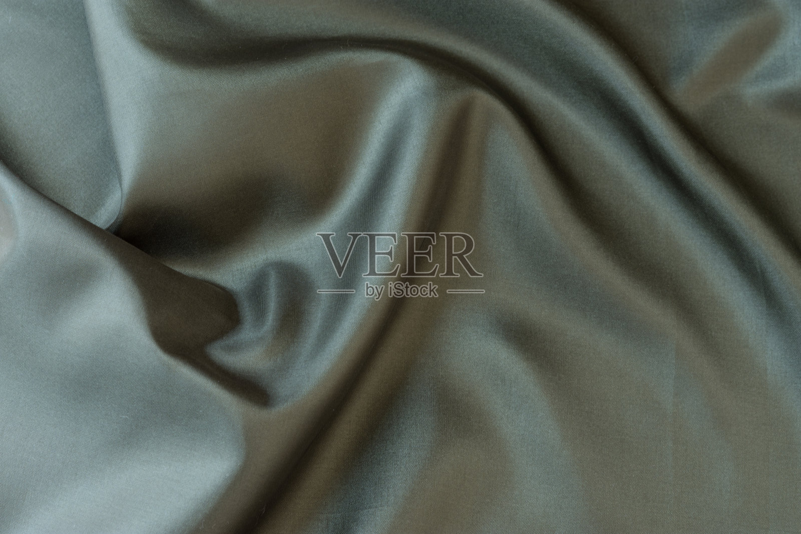 缎面绿色织物俯视图。布料上漂亮的褶皱照片摄影图片