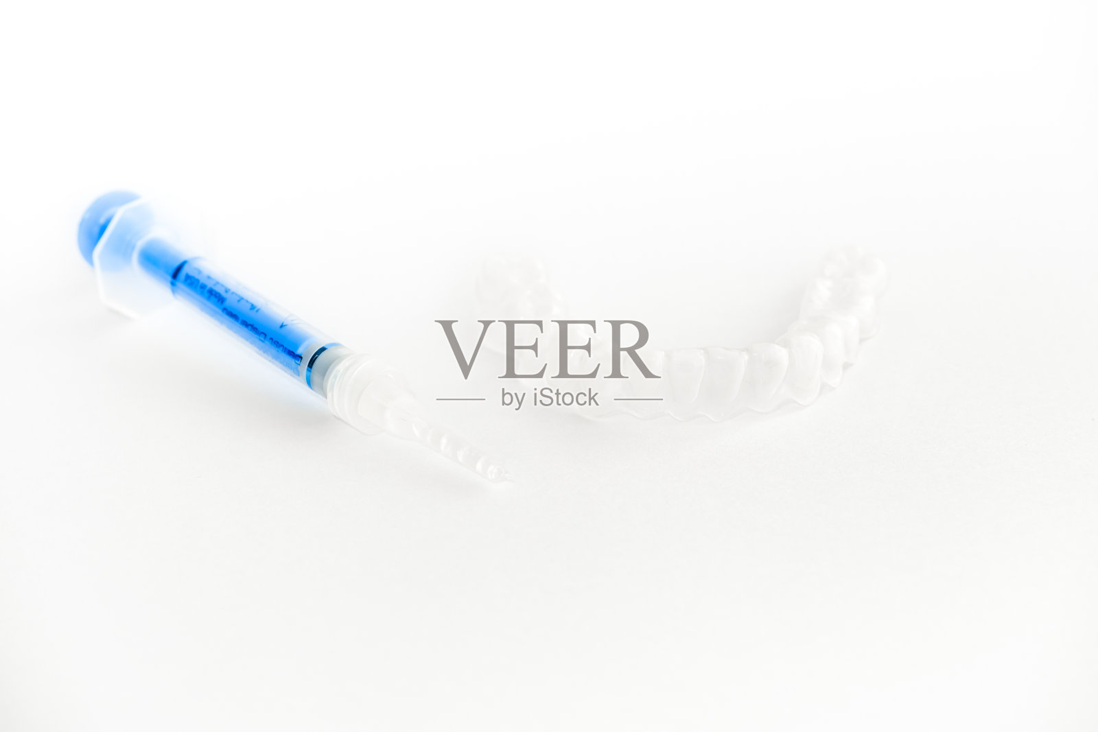 牙齿美白托盘和白底美白凝胶注射器照片摄影图片