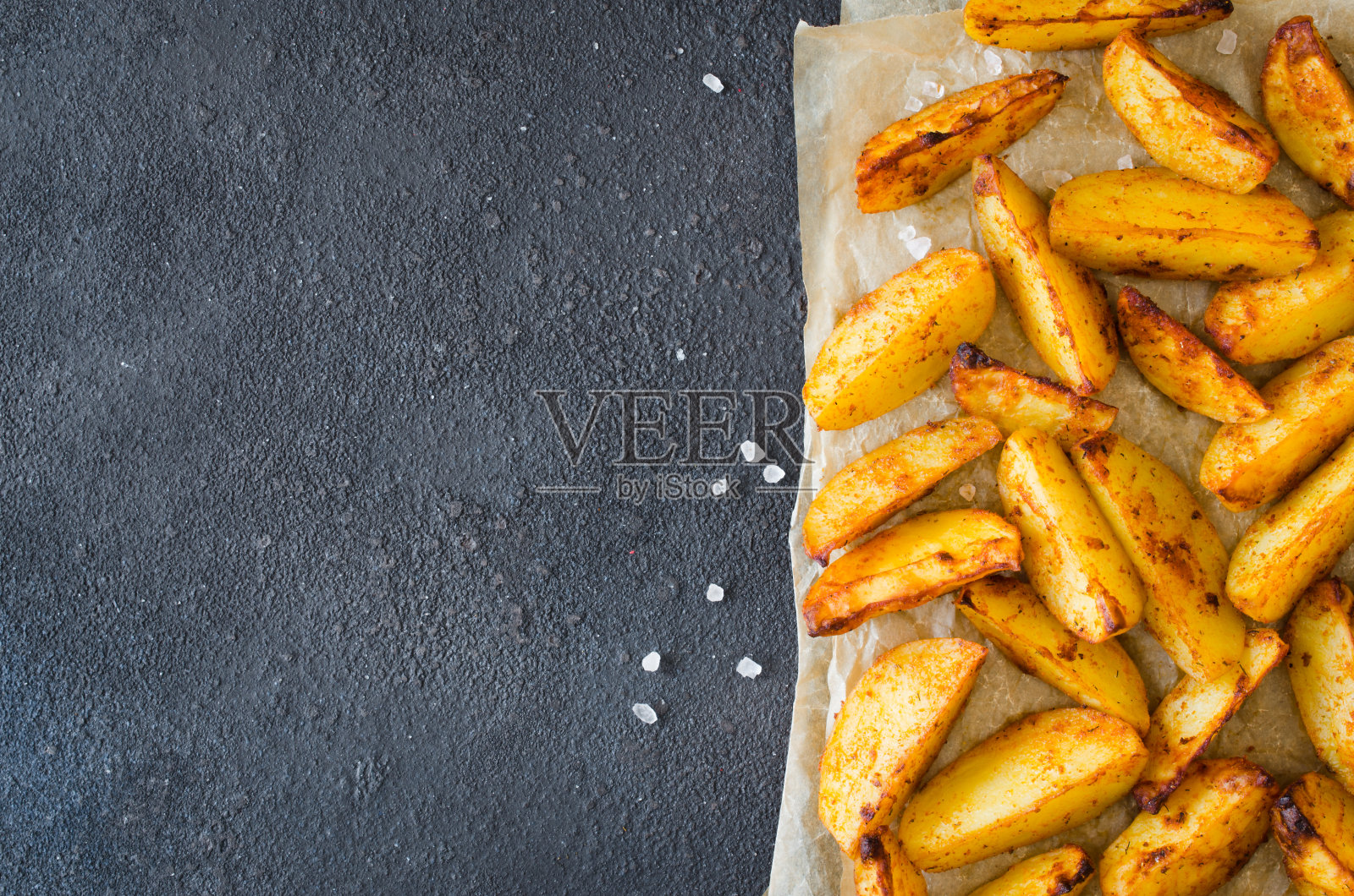 金色的香辣薯角,在深色的桌子上炸或烤。照片摄影图片