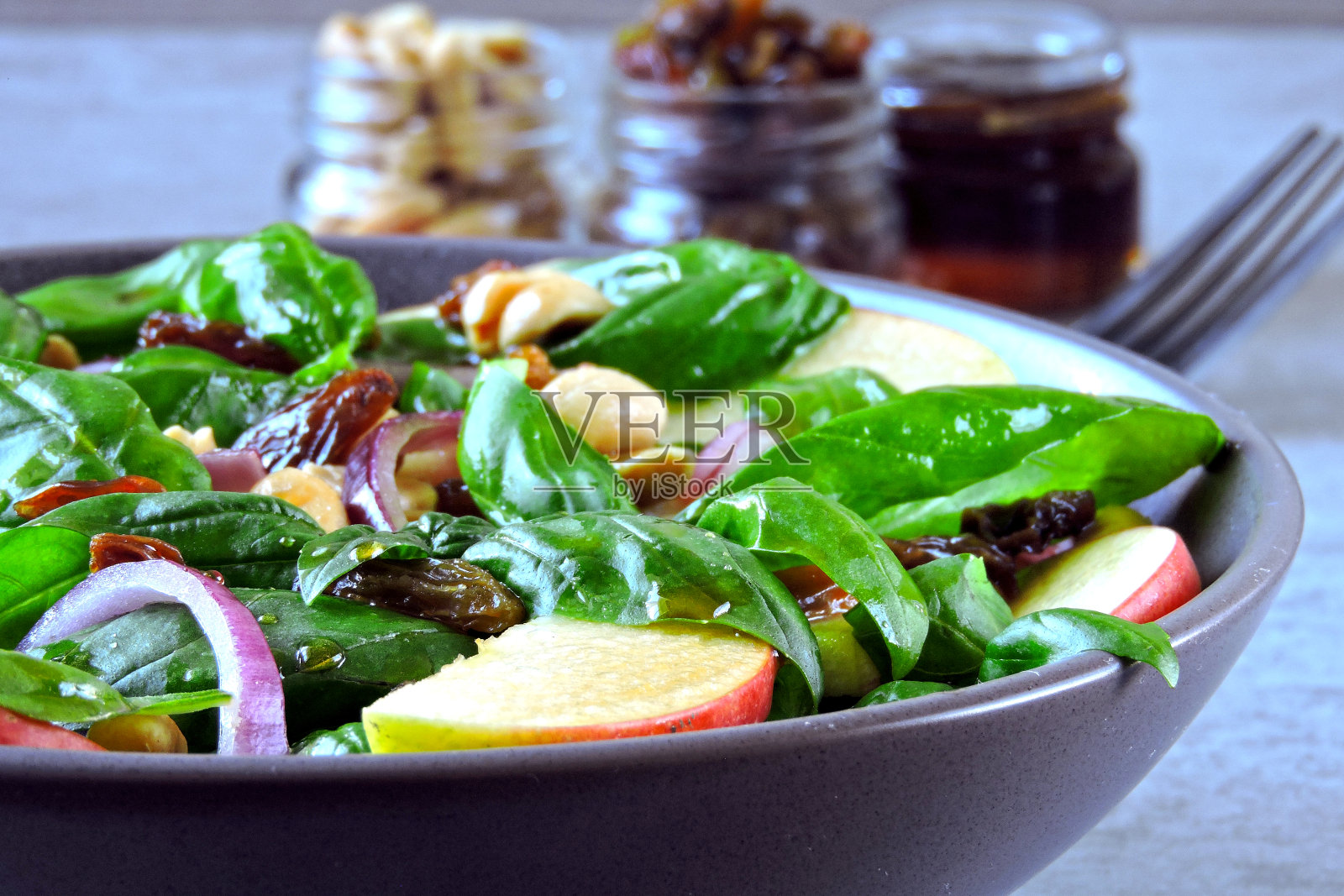 加罗勒,葡萄干和蓝洋葱的苹果沙拉。照片摄影图片