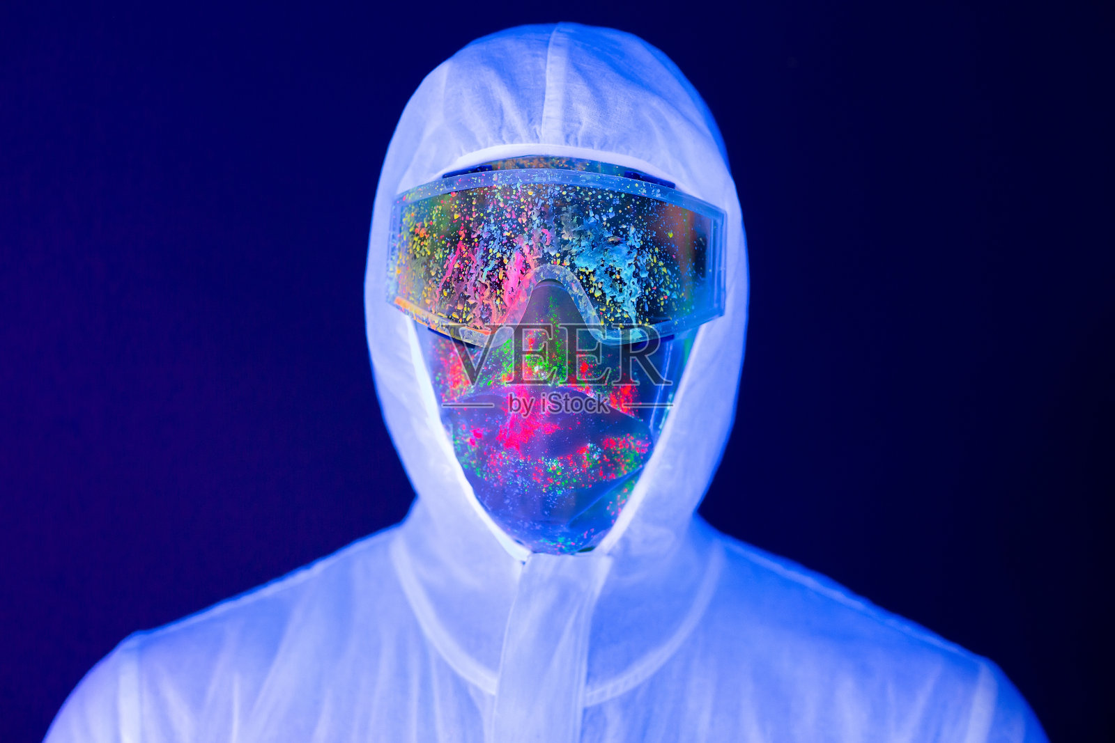 冠状病毒大流行期间,穿着防护服的男医生在紫外线霓虹灯下的肖像。疫情,新冠肺炎大流行照片摄影图片